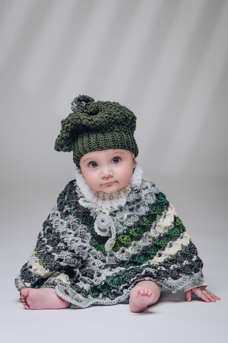 Fotoritratto di bambino con cappellino e vestito ricamato