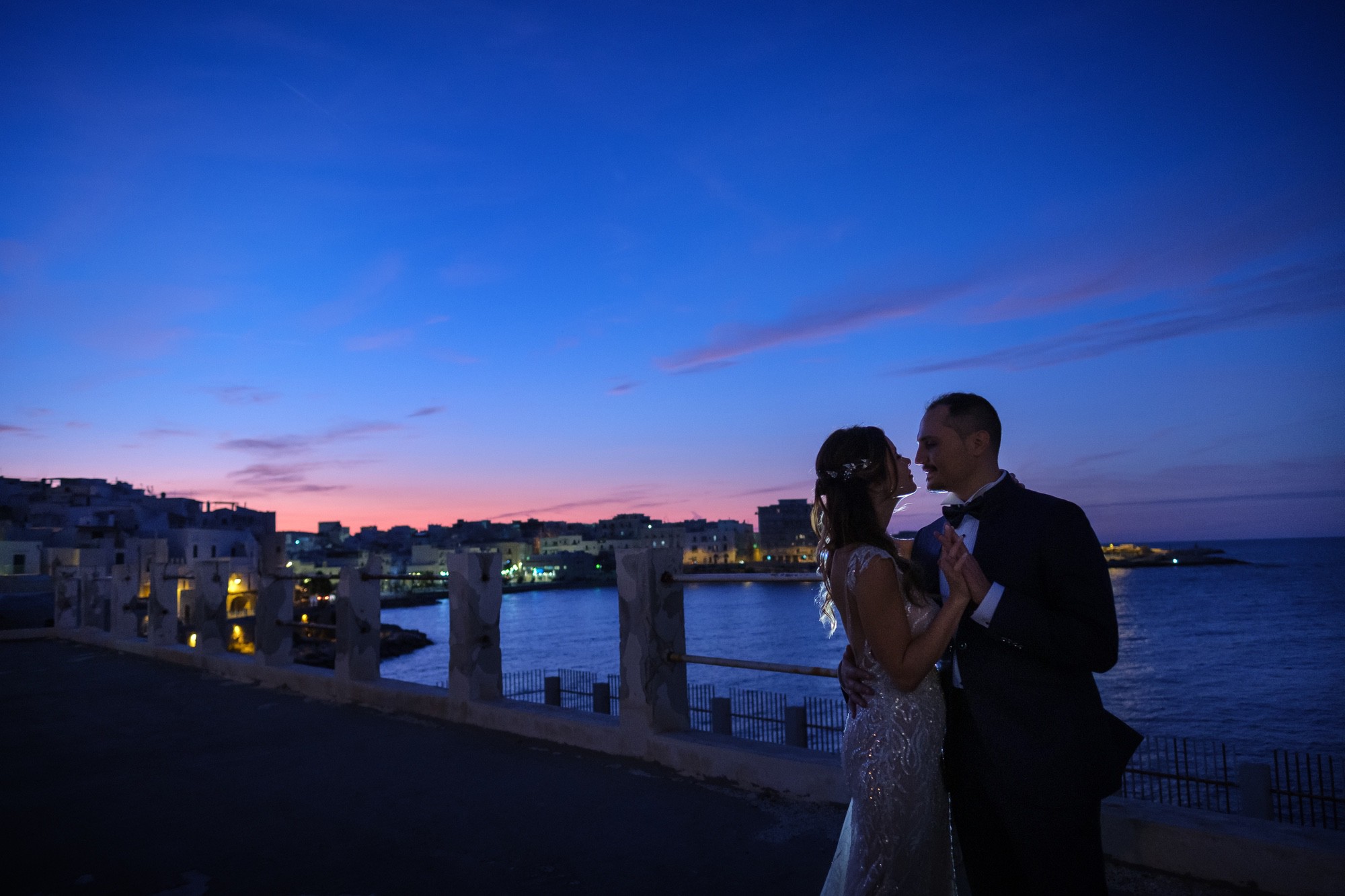 Foto di matrimonio di due sposi sul lungomare di Vieste, di sera