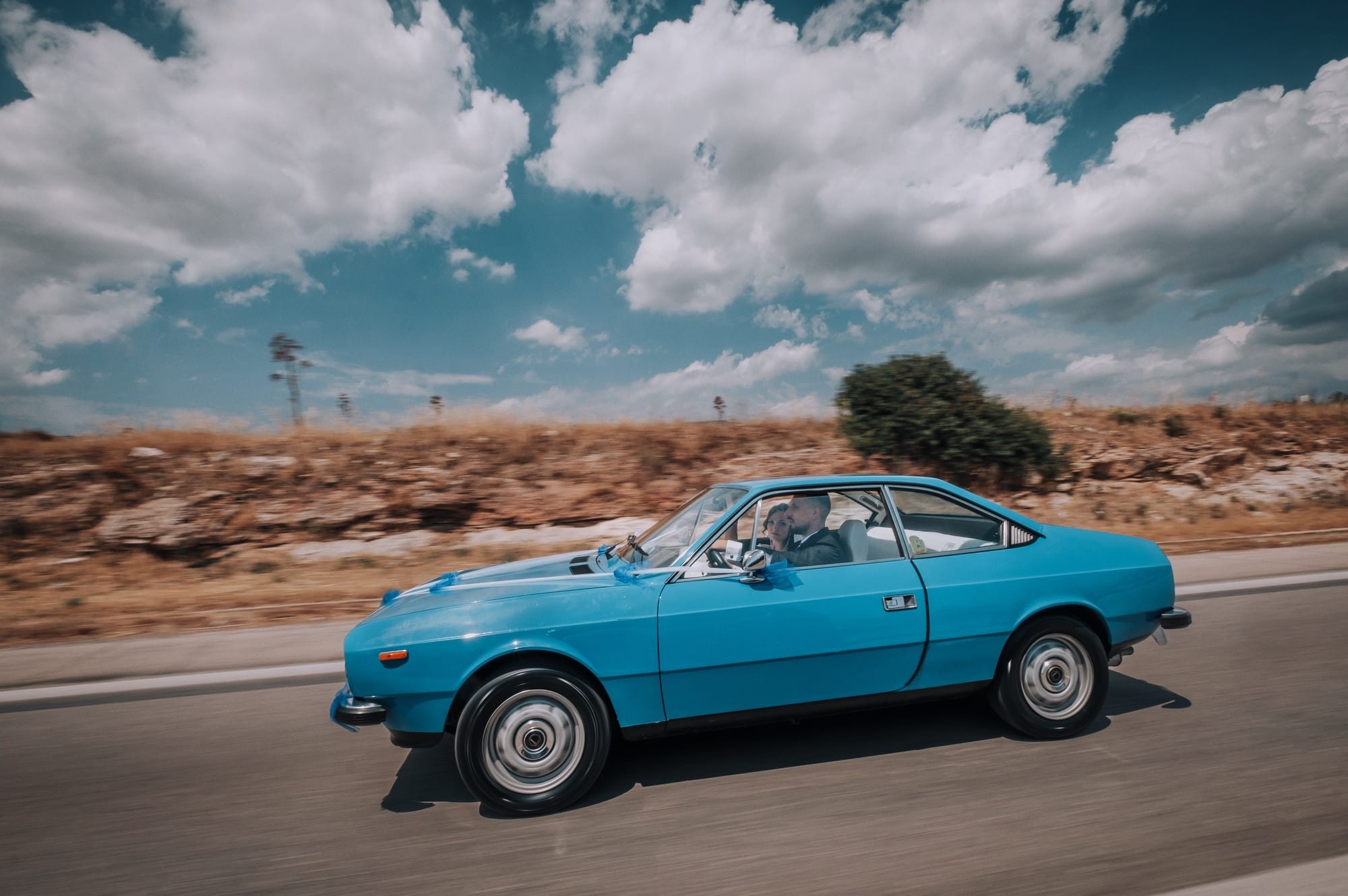 Foto di un reportage di matrimonio a bordo di un'auto d'epoca