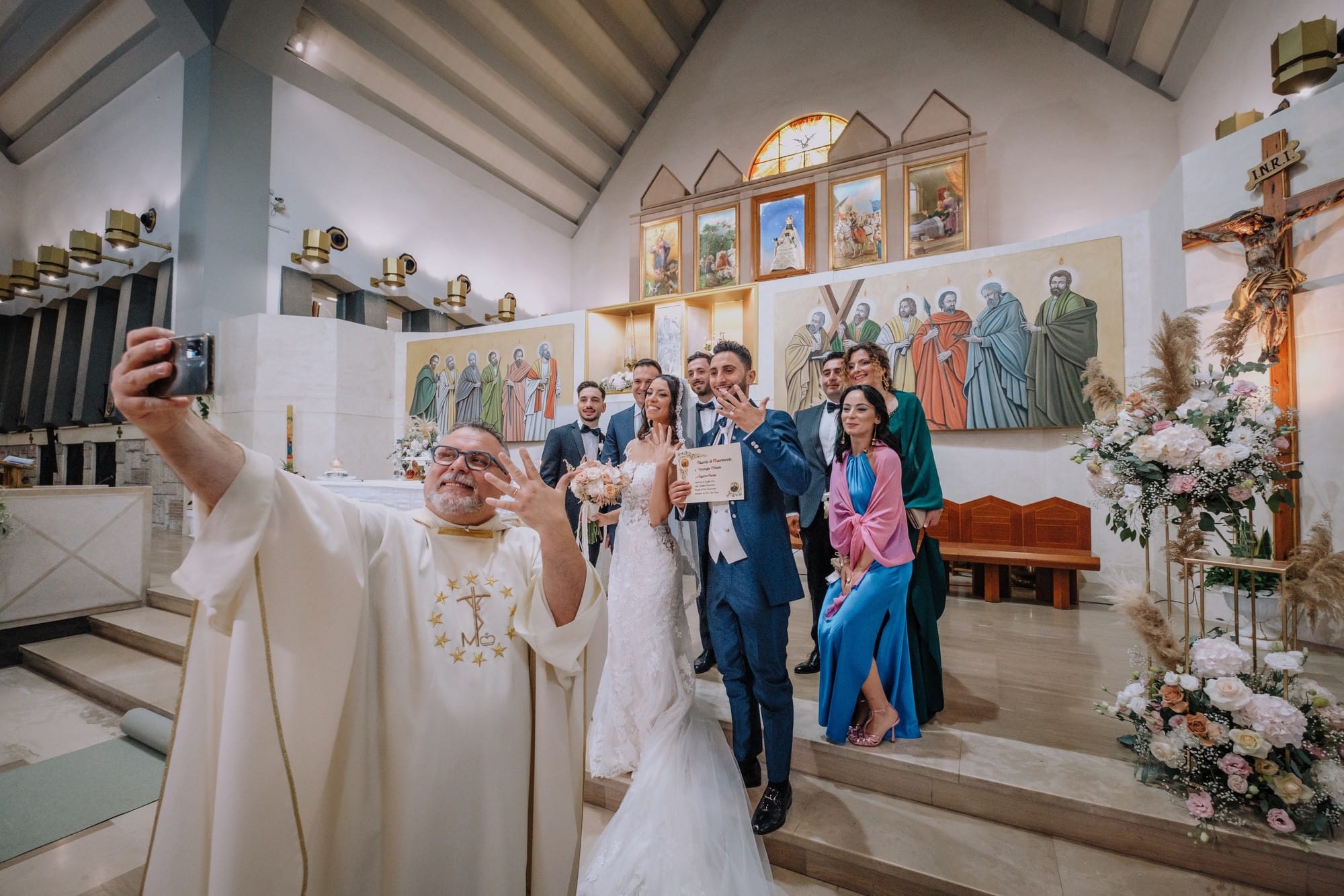 Shooting di nozze con selfie del prete, sposi e testimoni