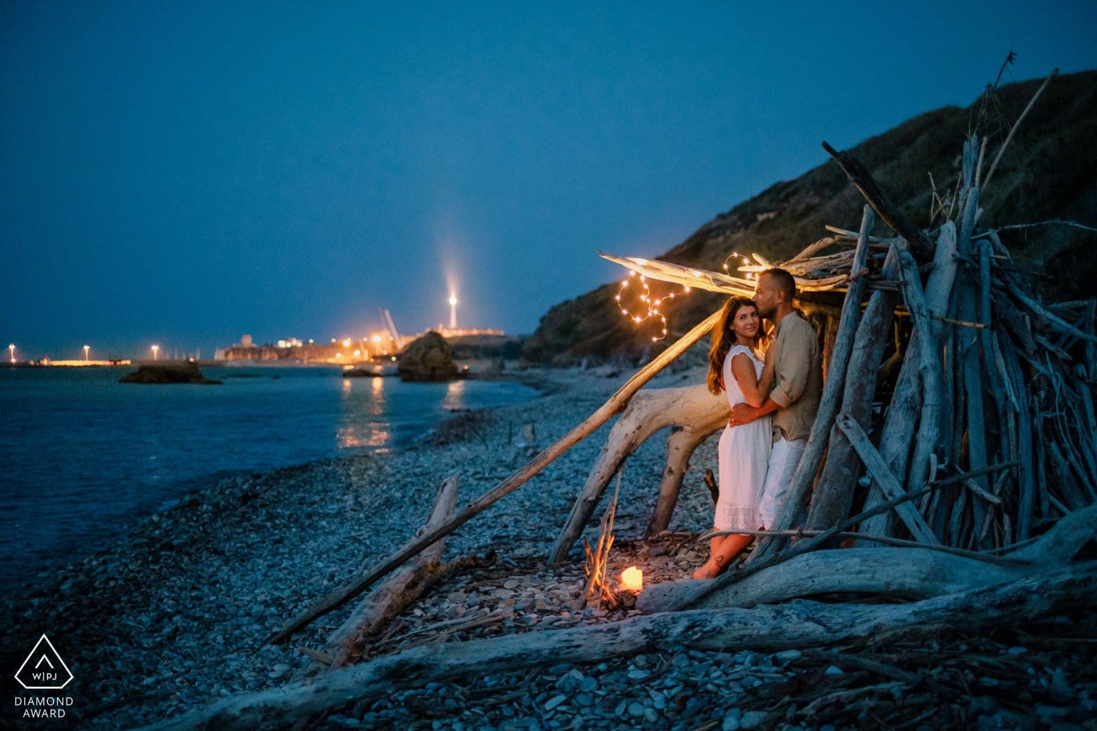 Foto di Pino Coduti con coppia in spiaggia di sera davanti al fuoco