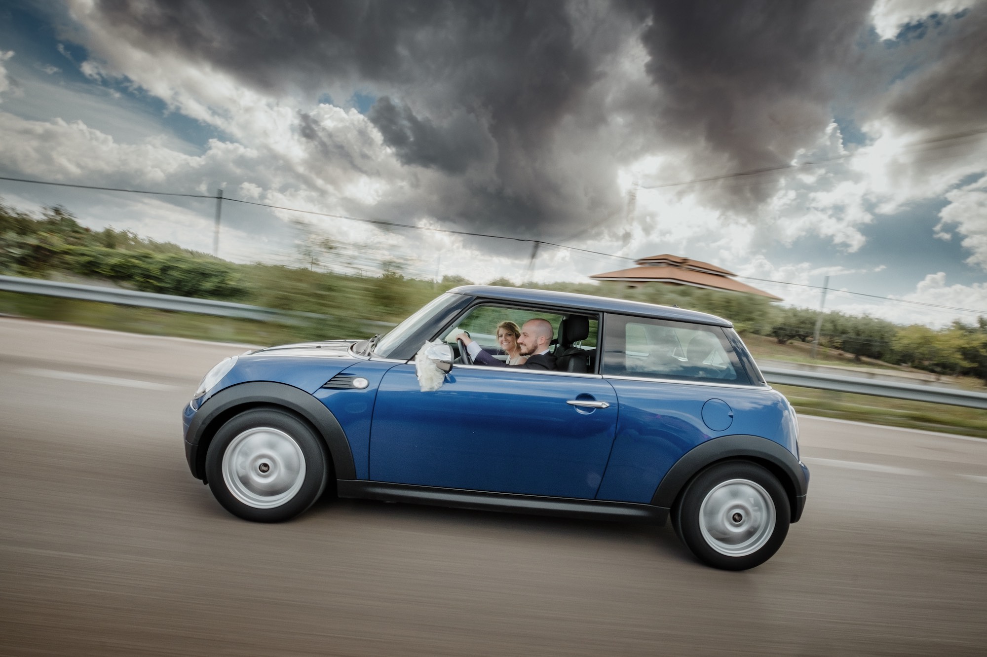 Gli sposi in viaggio con la loro amata MINI blu
