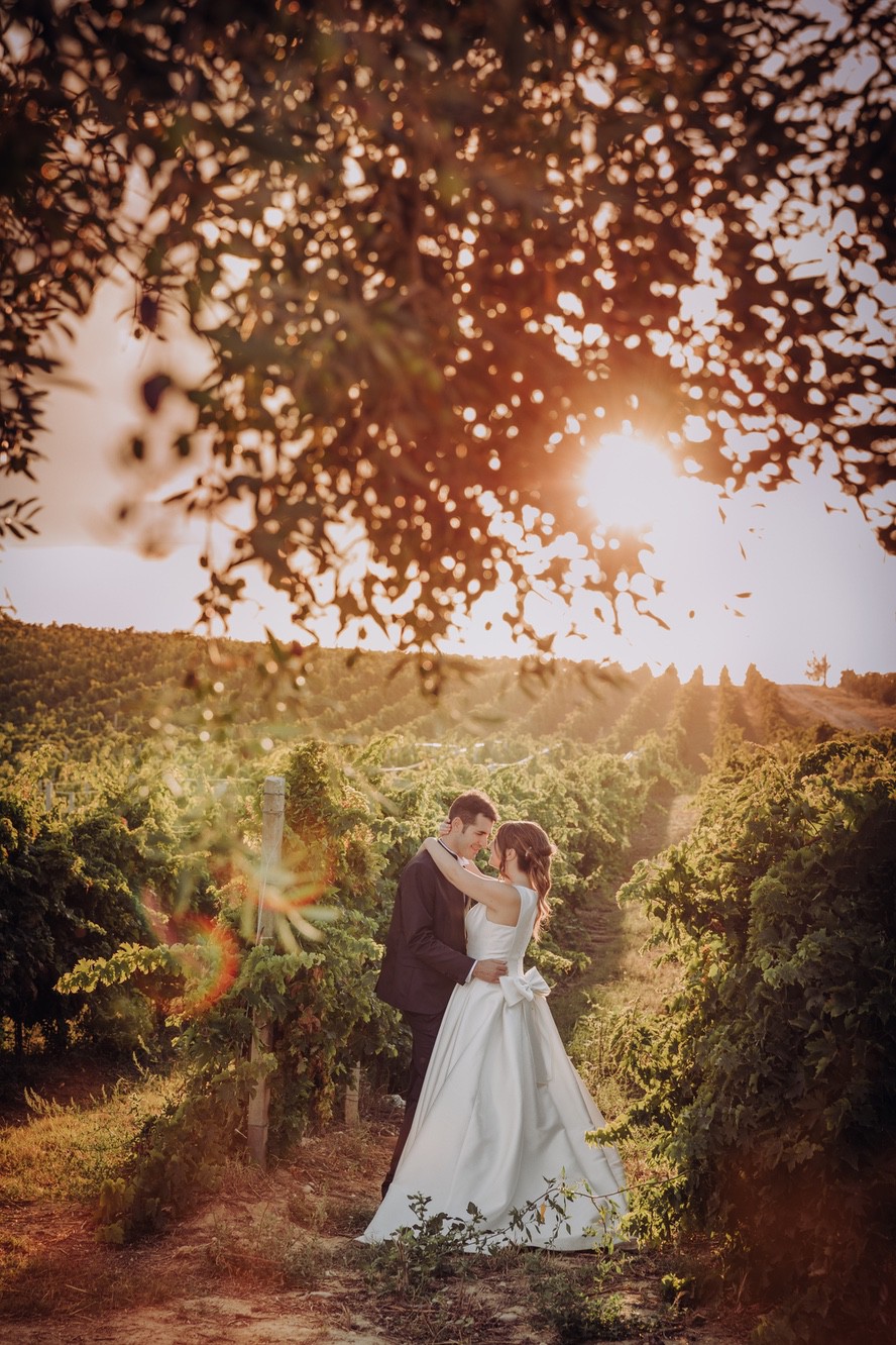 Foto di sposi che si baciano tra i vigneti