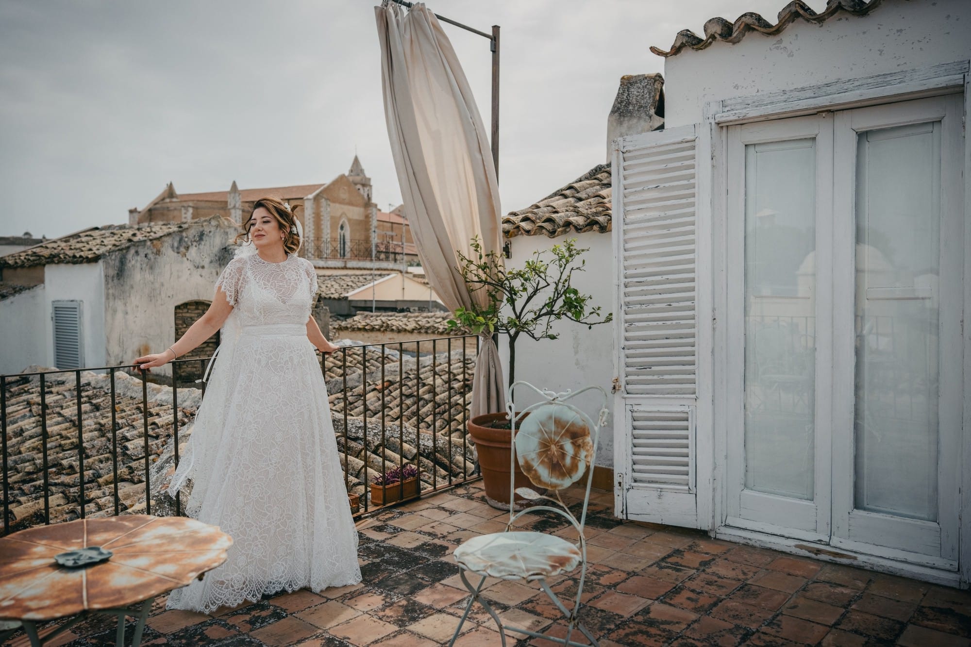 Scatto professionale di una sposa sul terrazzo a Lucera con sfondo sui tetti