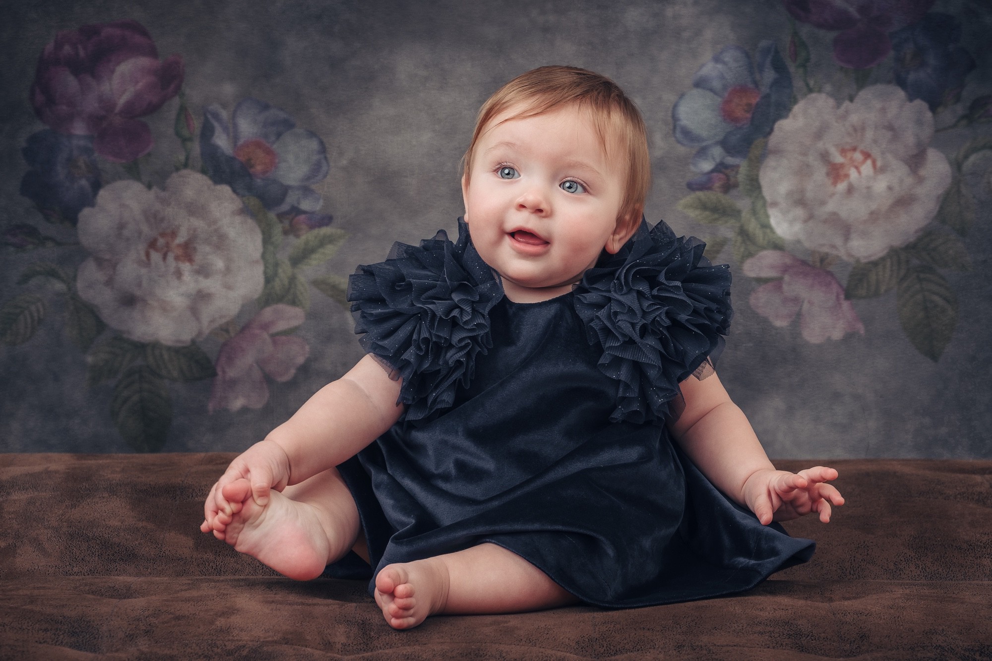 Fotoritratto di una neonata in primo piano, con abito da cerimonia