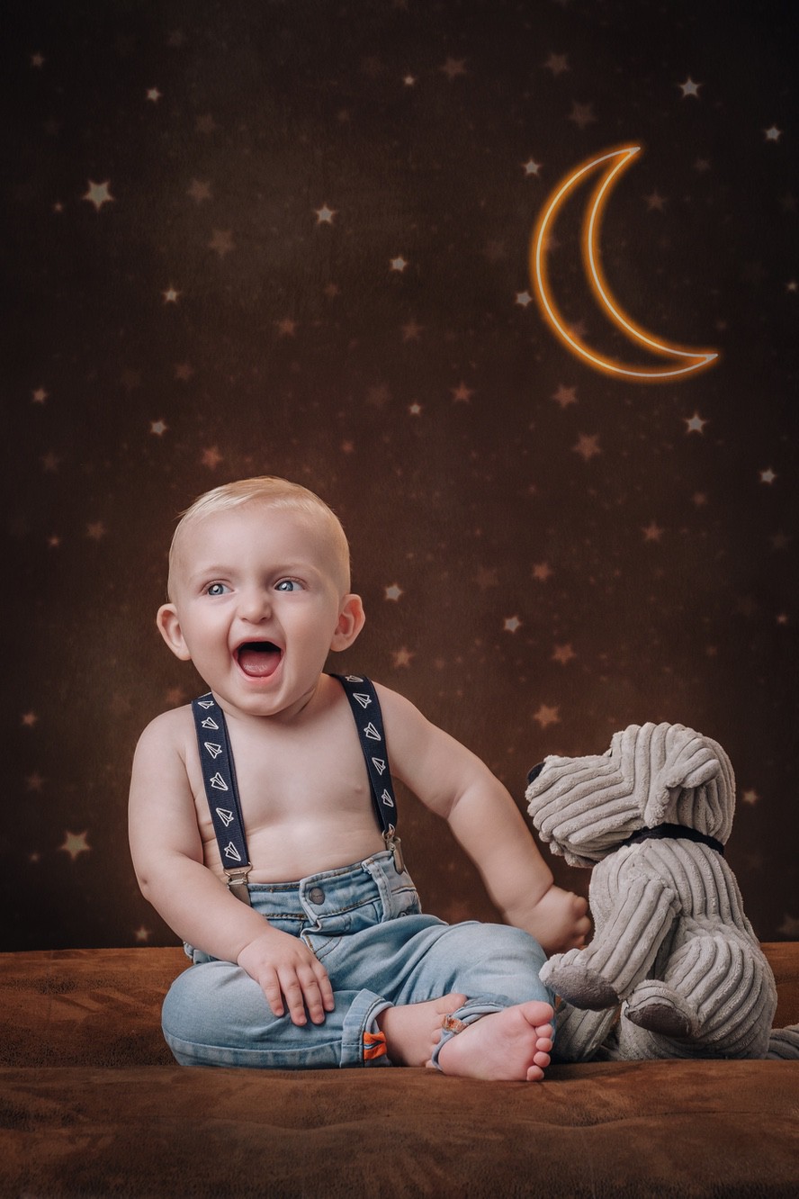 Fotoritratto di un neonato con bretelle e jeans