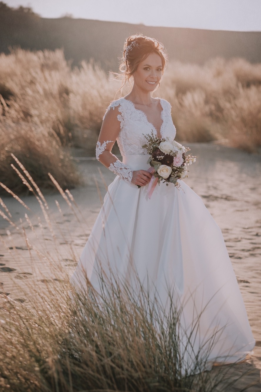 Foto di una sposa con bouquet in un paesaggio rurale