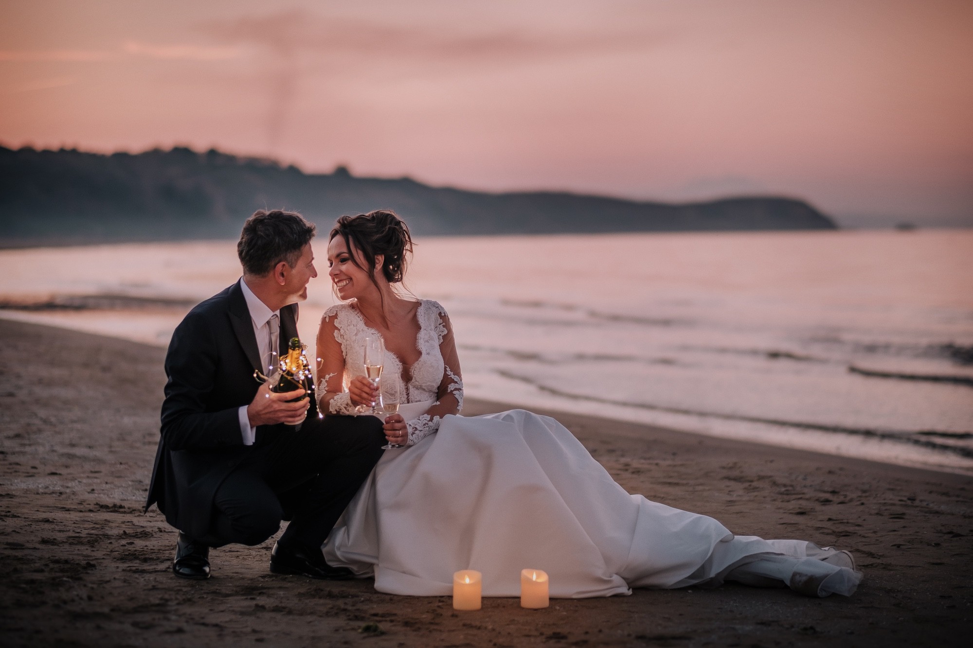 Foto sposi in spiaggia a Punta Penna al tramonto con candele