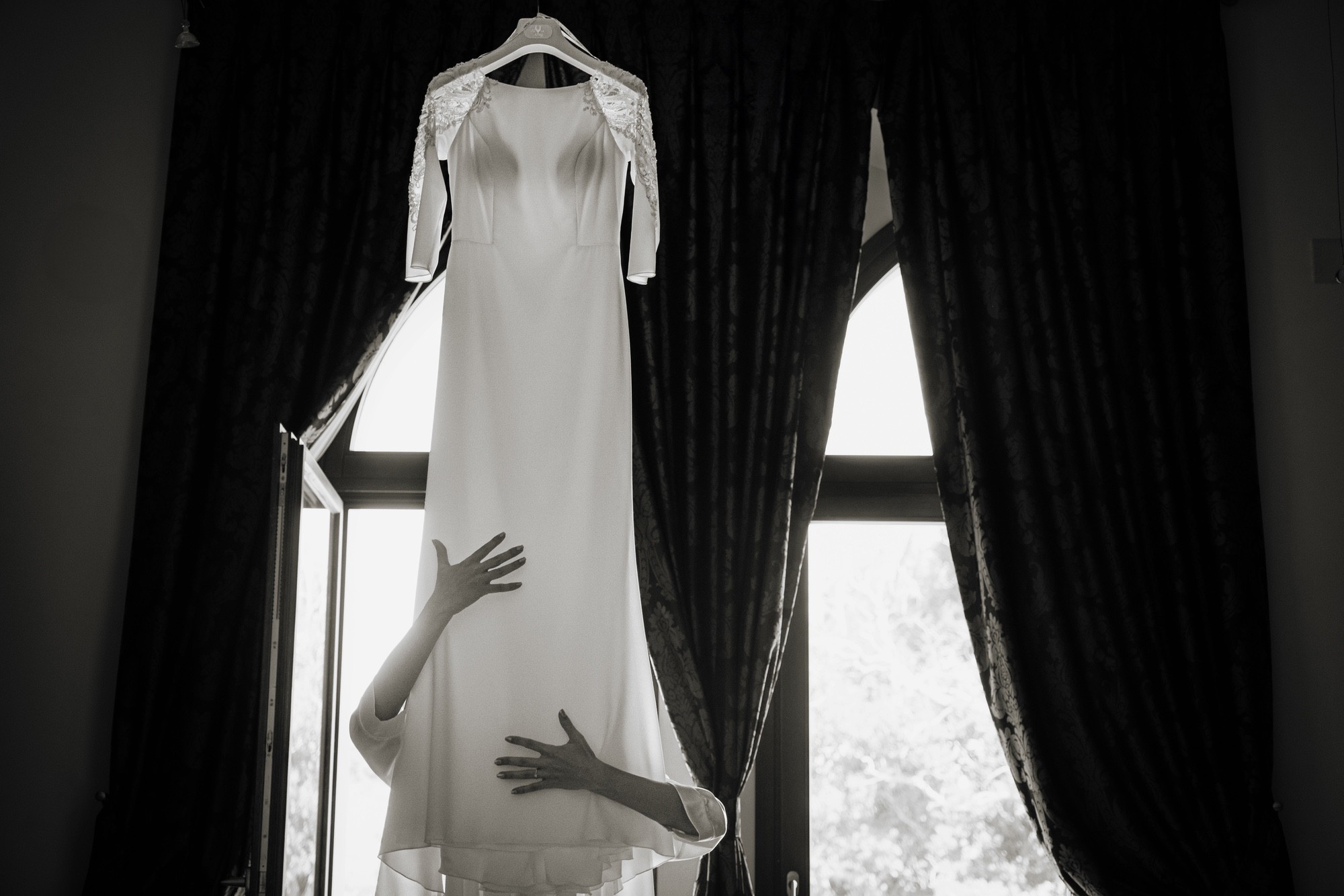 Foto di una sposa che sta per indossare il suo abito bianco
