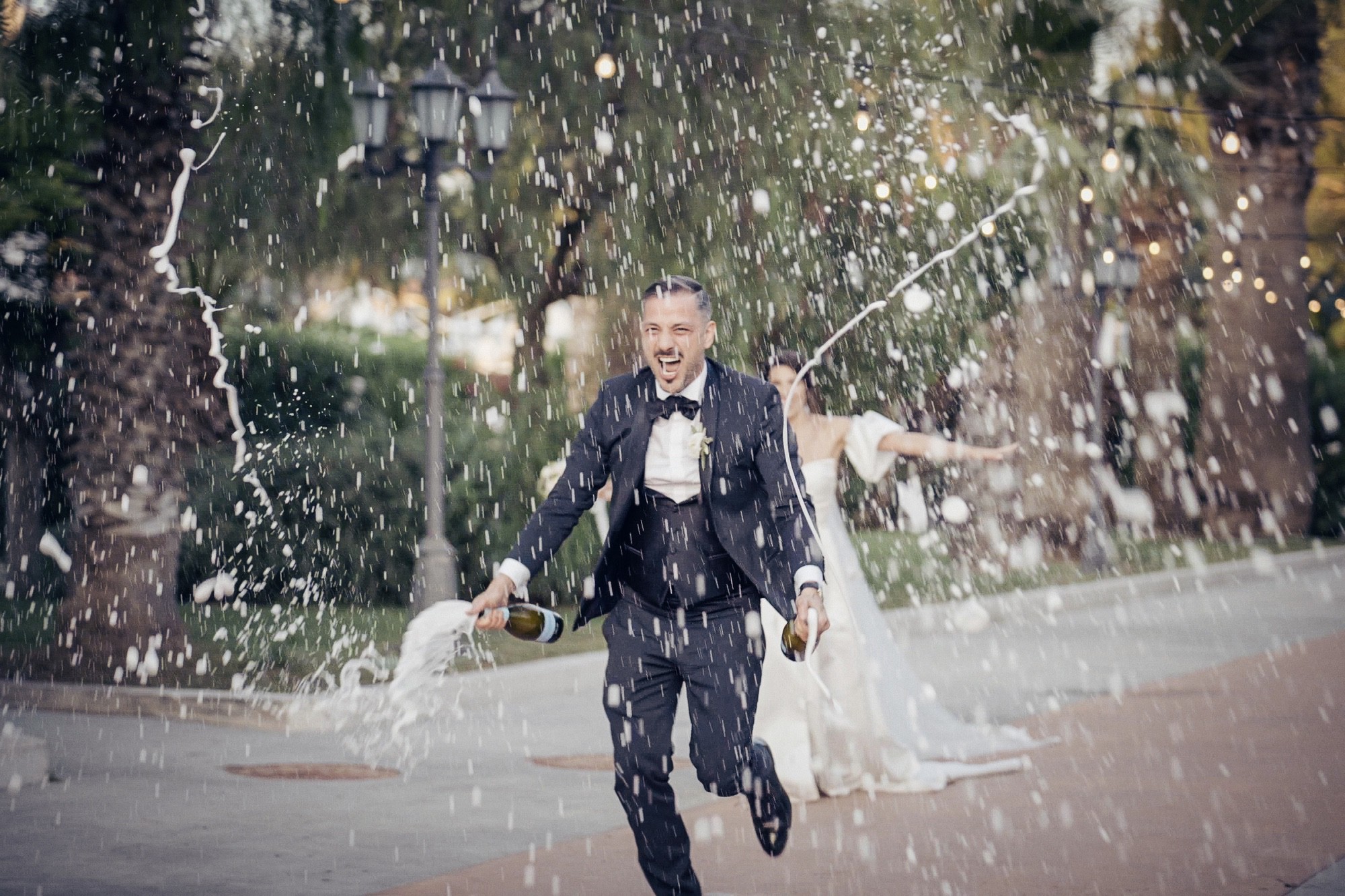 Sposo che festeggia spruzzando spumante