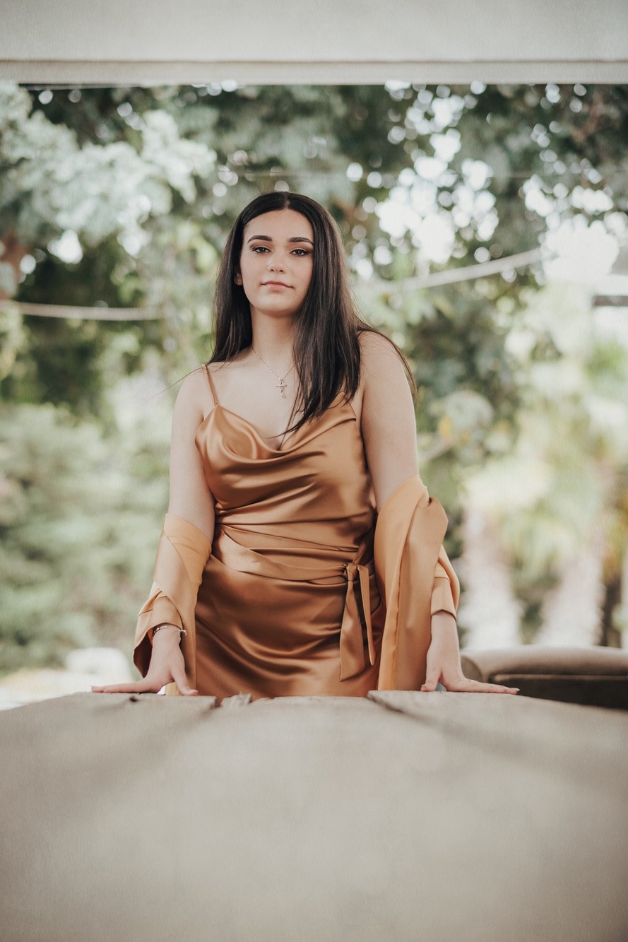Ragazza elegante Ragazza con abito elegante color rame da cerimonia