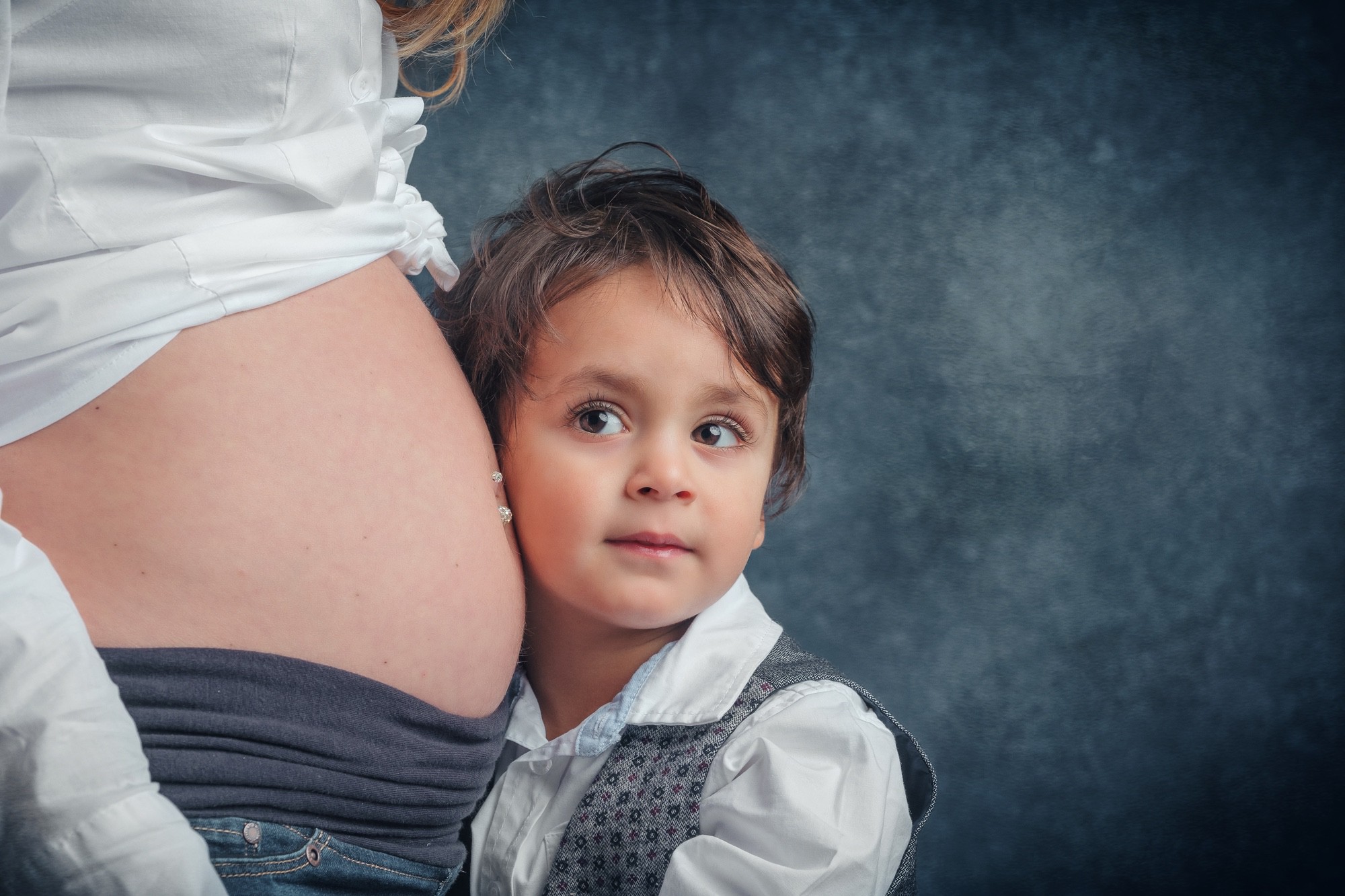 Bimbo e pancione Bimbo con l'orecchio vicino al pancione