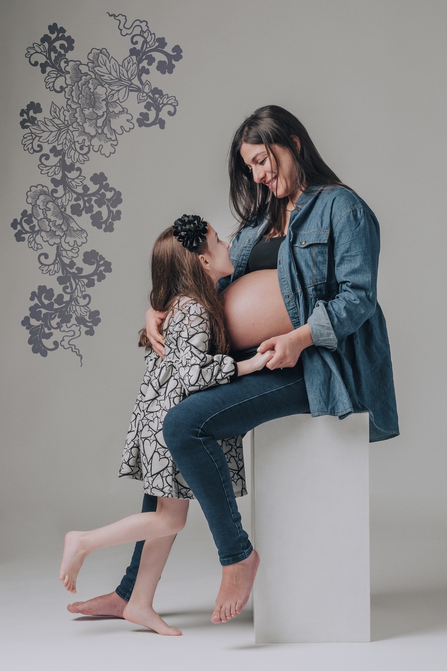 Scatto professionale di una futura mamma con la figlia grande