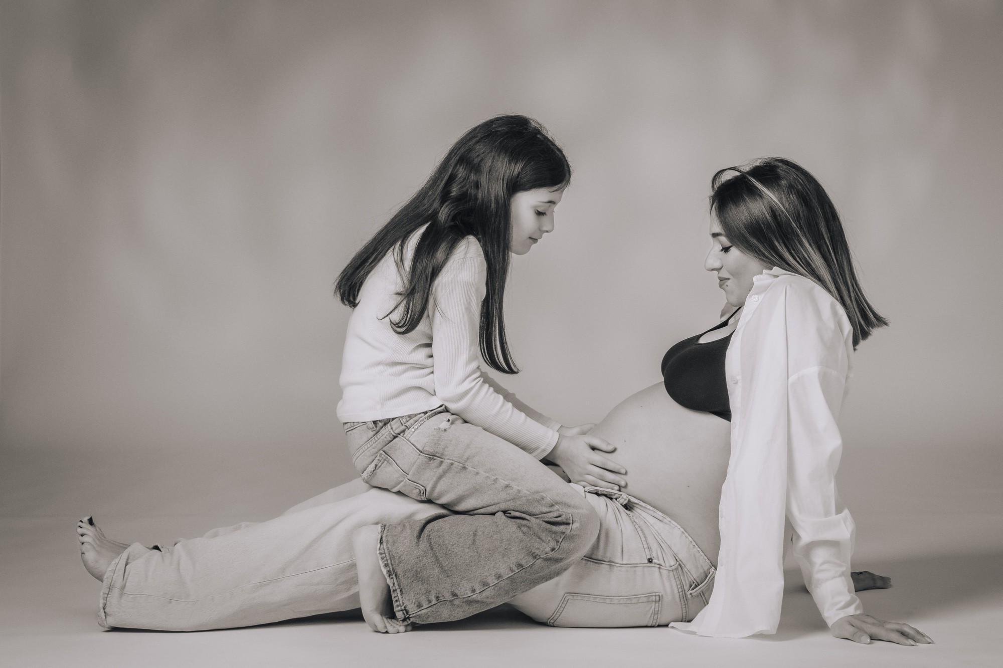 Ricordo di mamma e figlia Ricordo di una mamma in attesa con la figlia grande sulle gambe