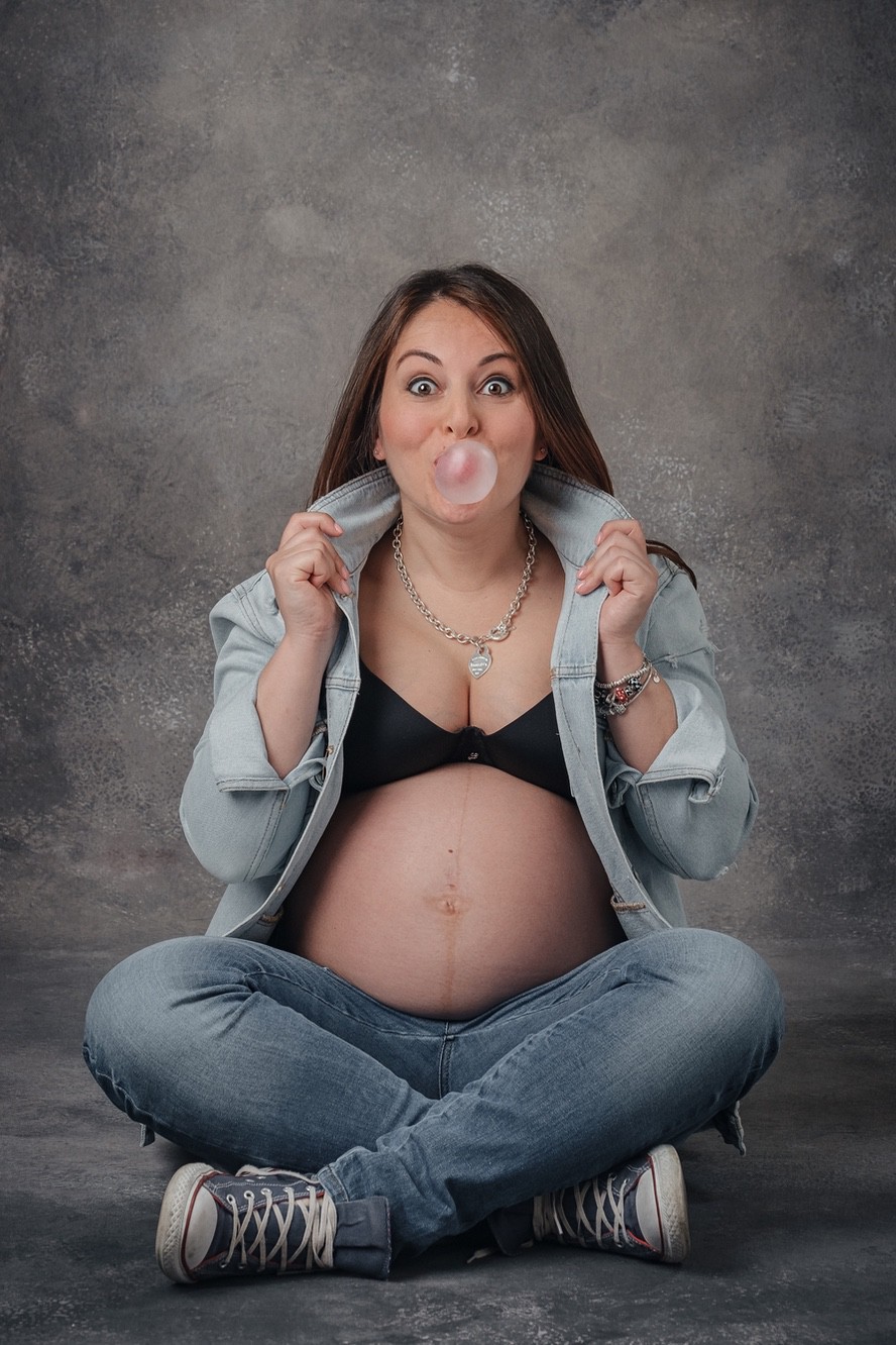 Mamma con pancione e chewing gum Mamma con pancione che fa una bolla col chewing gum