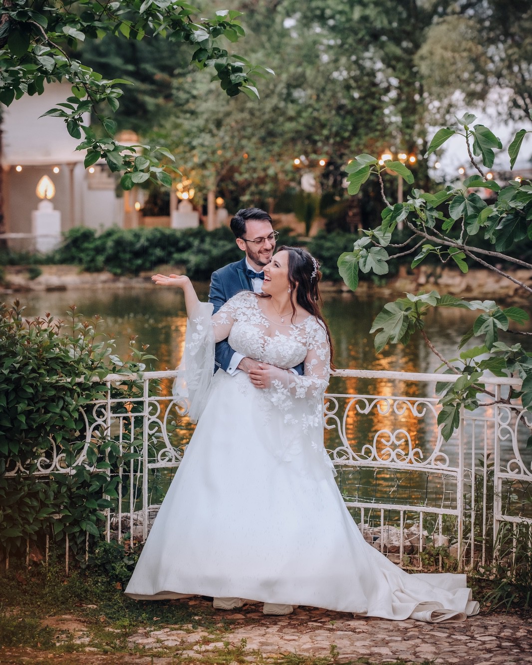 Coppia di sposi all'aperto davanti ad un laghetto.