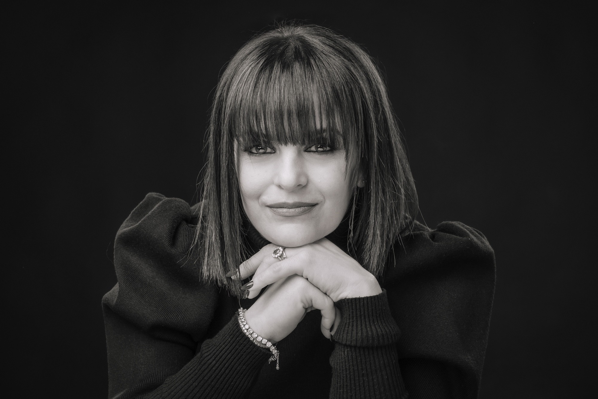 Foto ritratto professionale Primo piano in bianco e nero di una donna con il mento poggiaot sulle mani.