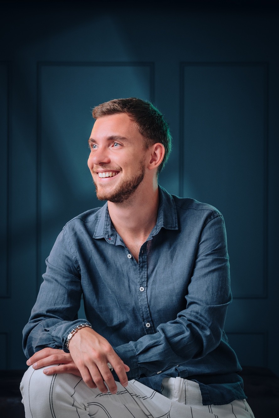 Foto ritratto professionale di un ragazzo sorridente in abiti casual.