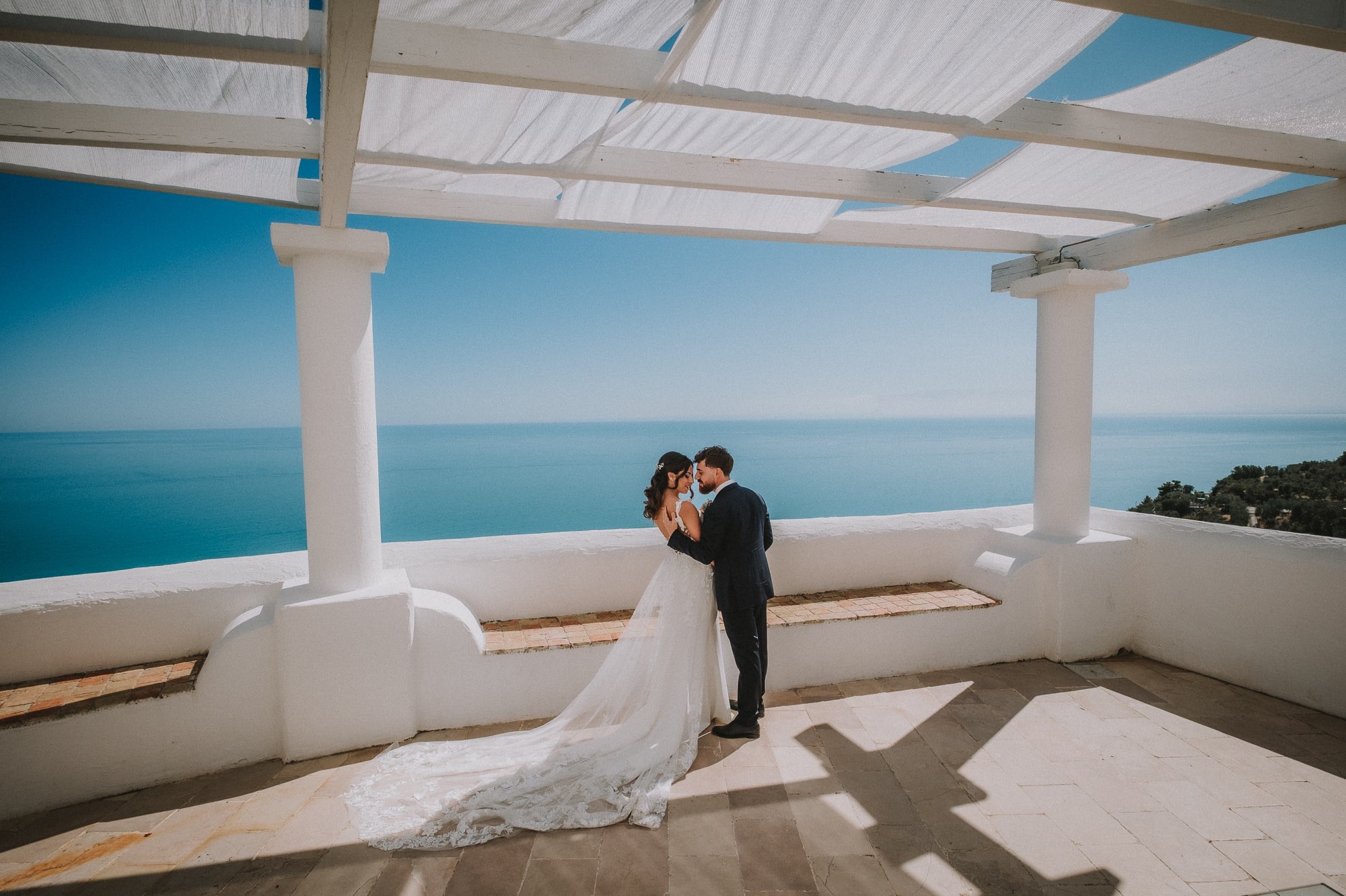 Fotografia di una coppia di sposi su una terrazza vista mare.