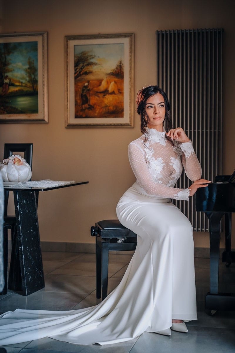 Sposa in posa in una sala ricevimenti in Puglia illuminata dalla luce morbida d’autunno.