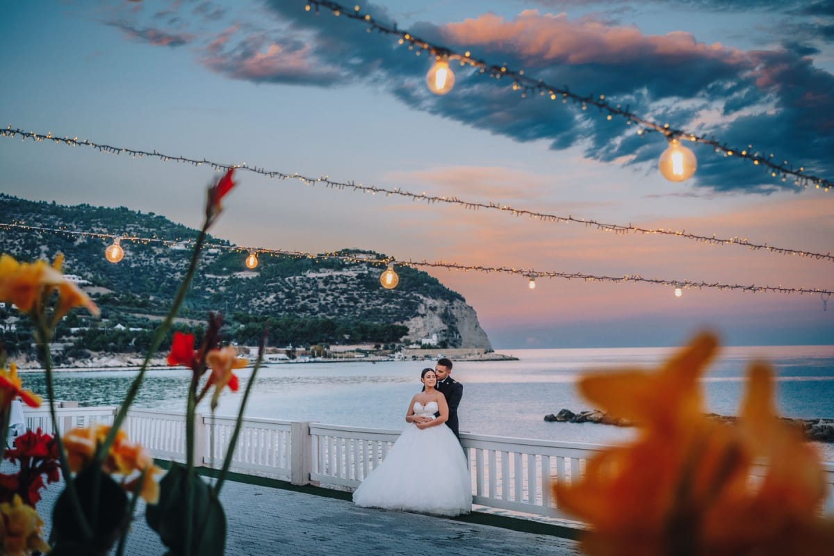 Sposi al tramonto sulla costa di Mattinata nel Gargano durante matrimonio autunnale.