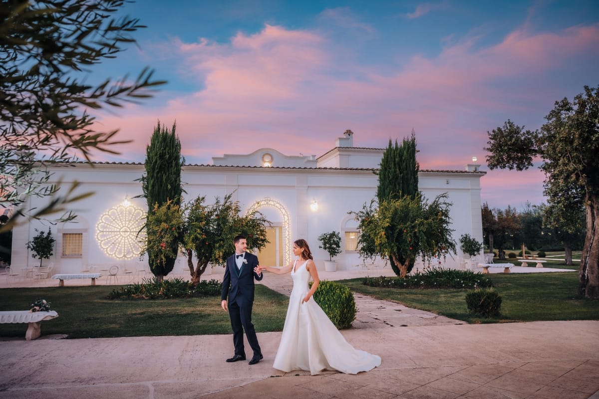 Sposi si tengono per mano al tramonto.