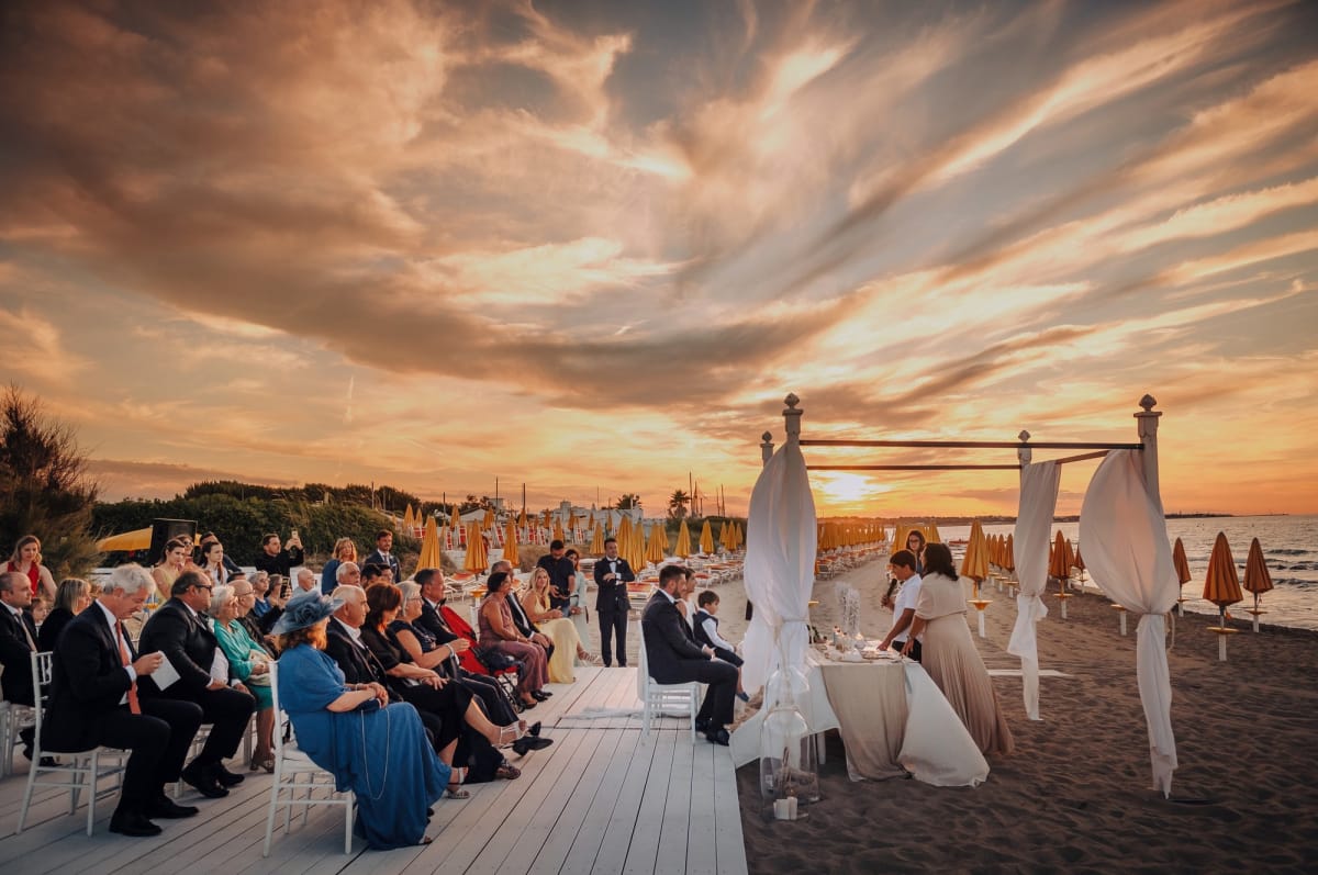 Panoramica di un matrimonio all'aperto durante il tramonto.