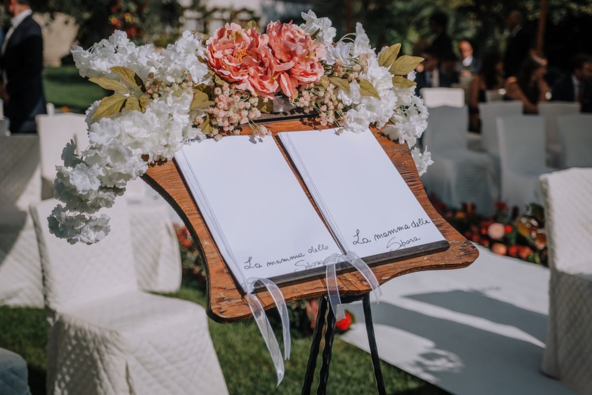 Leggio decorato con fiori e quaderno durante un rito di matrimonio civile.
