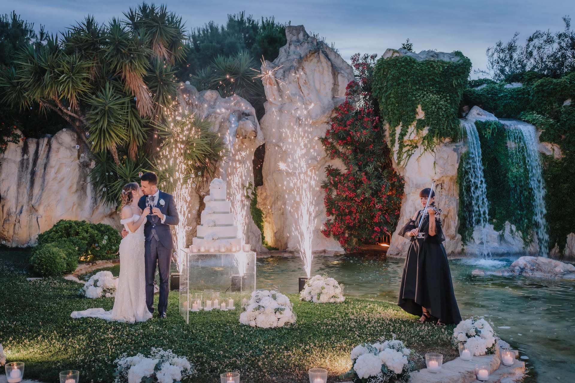 Sposi fotografati di notte in giardino durante il ricevimento di matrimonio.