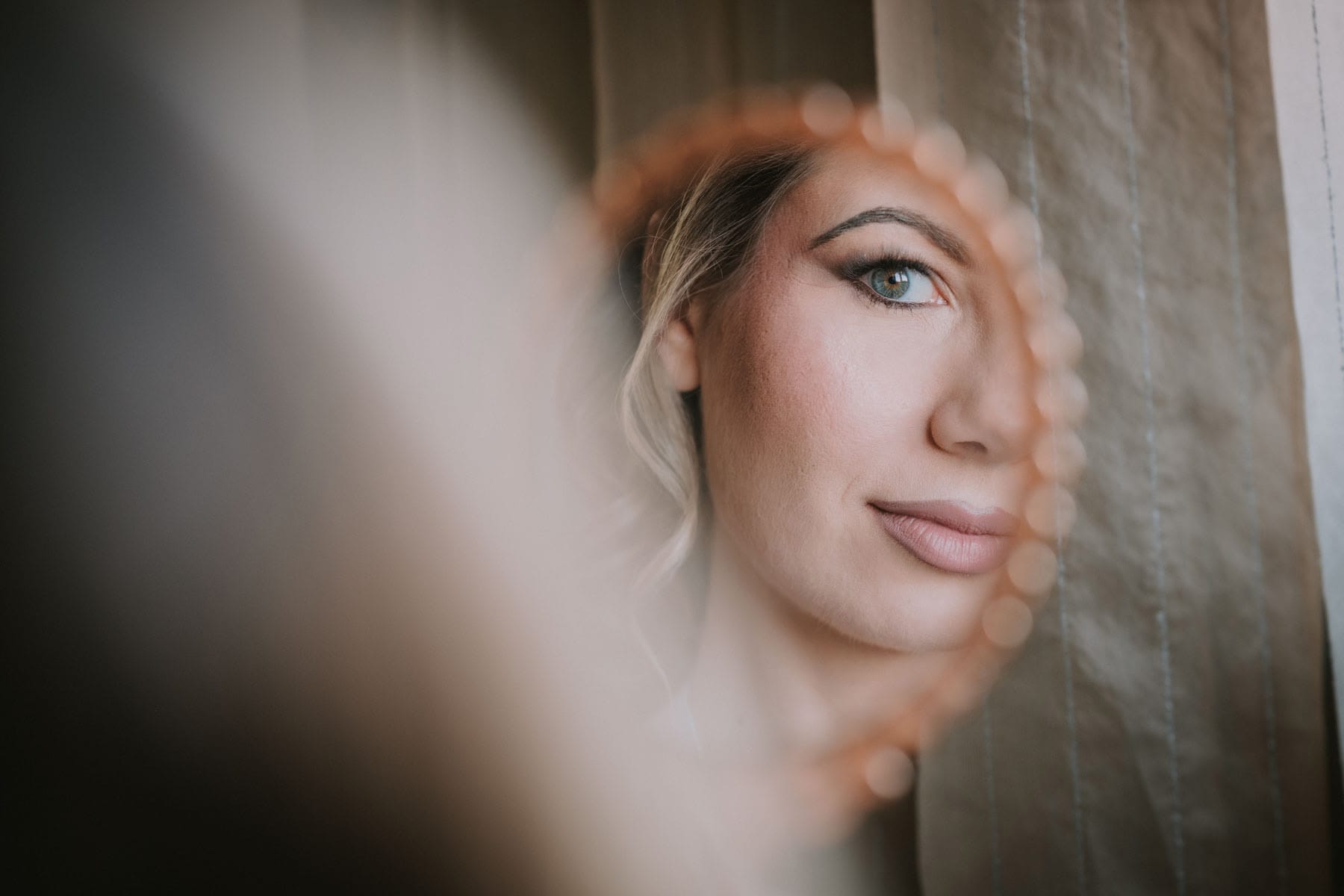 Ritratto della sposa realizzato attraverso un riflesso durante il giorno del matrimonio.